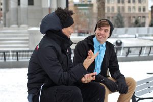 Conversation of two people sitting on a bench. 